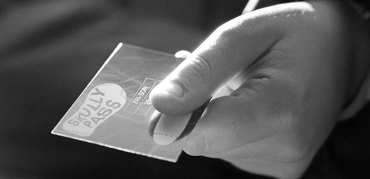 Image noir et blanc d'une main qui tend un abonnement Skully Pass 