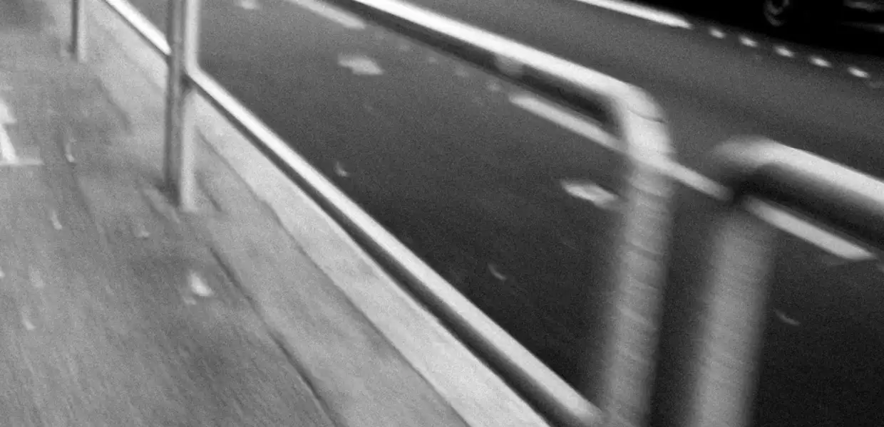 Photo noir et blanc flou des barrières au bord de la route