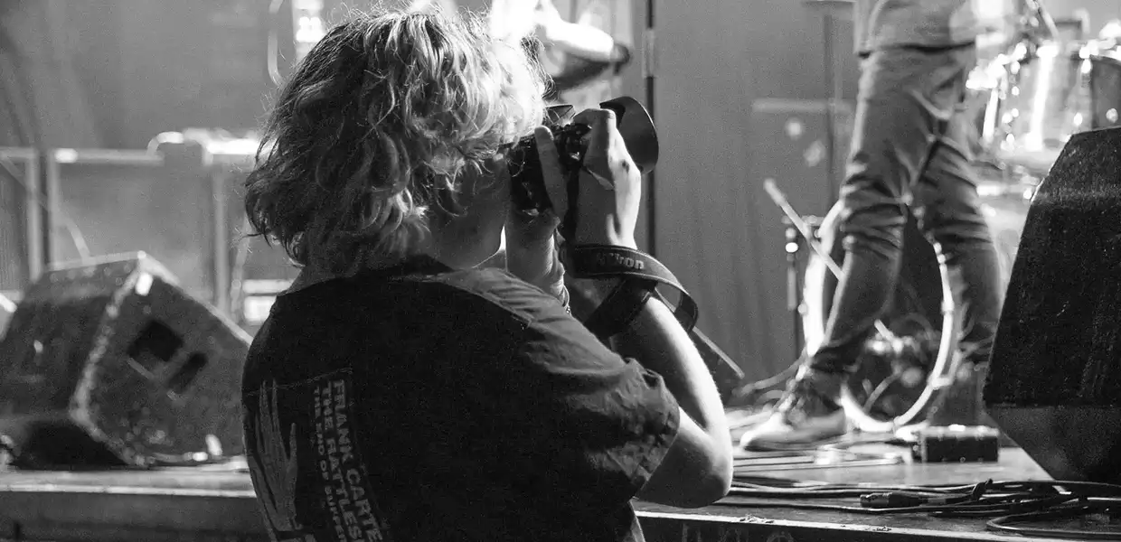 Photo en noir et blanc d'une photographe lors d'un concert