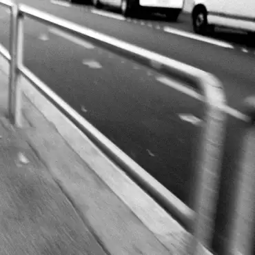 Photo noir et blanc flou des barrières au bord de la route