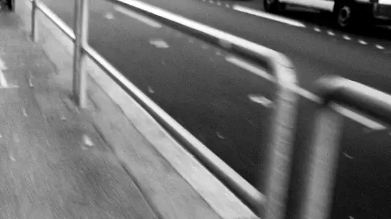 Photo noir et blanc flou des barrières au bord de la route