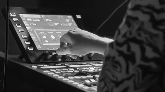 Photo en noir et blanc d'une main sur une console lumière