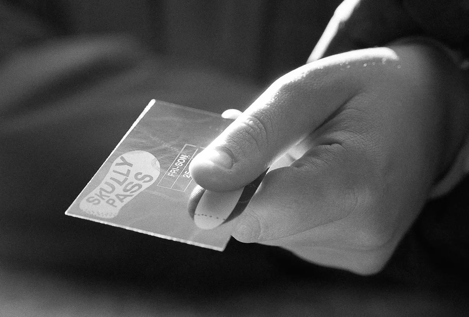 Image noir et blanc d'une main qui tend un abonnement Skully Pass 