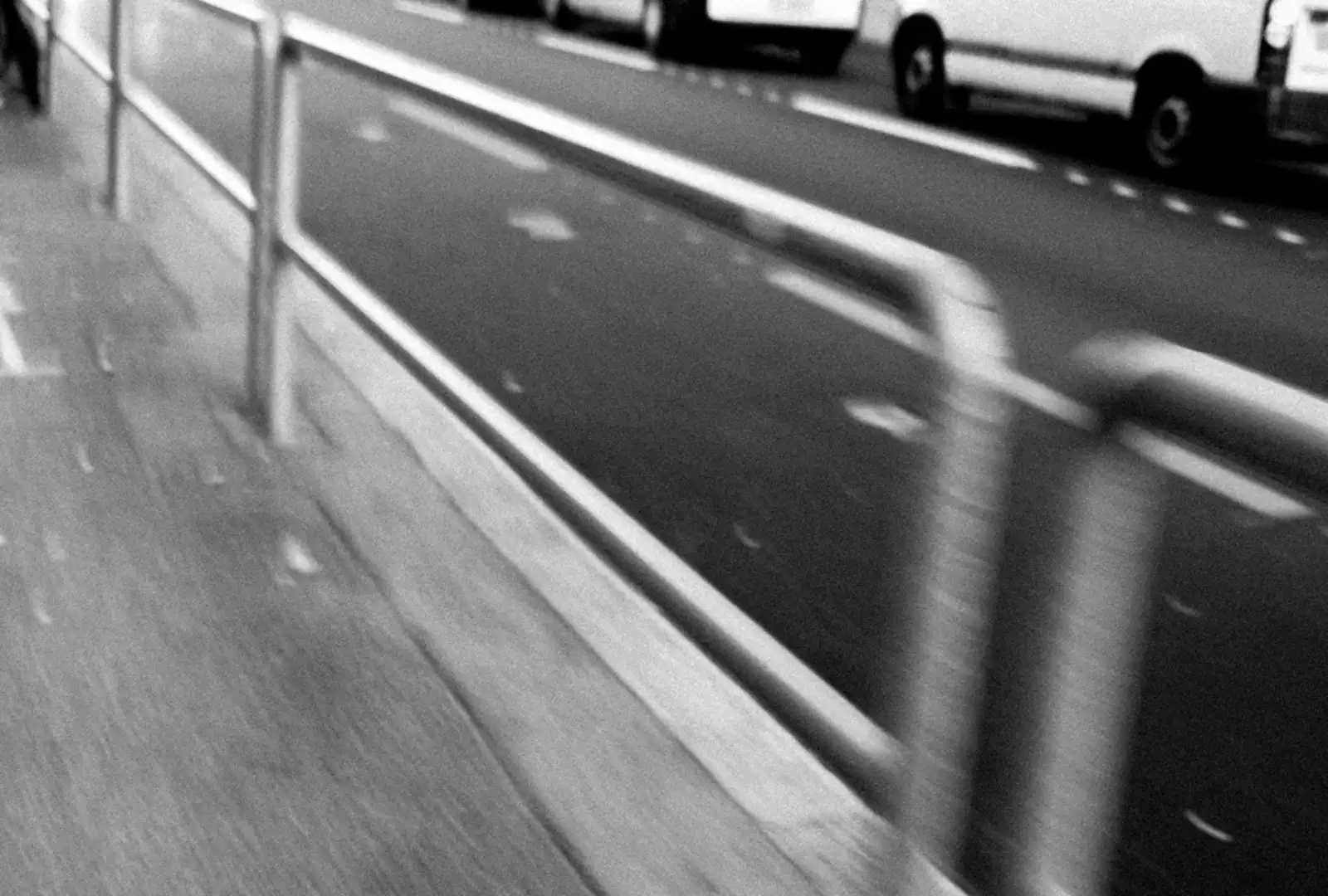 Photo noir et blanc flou des barrières au bord de la route