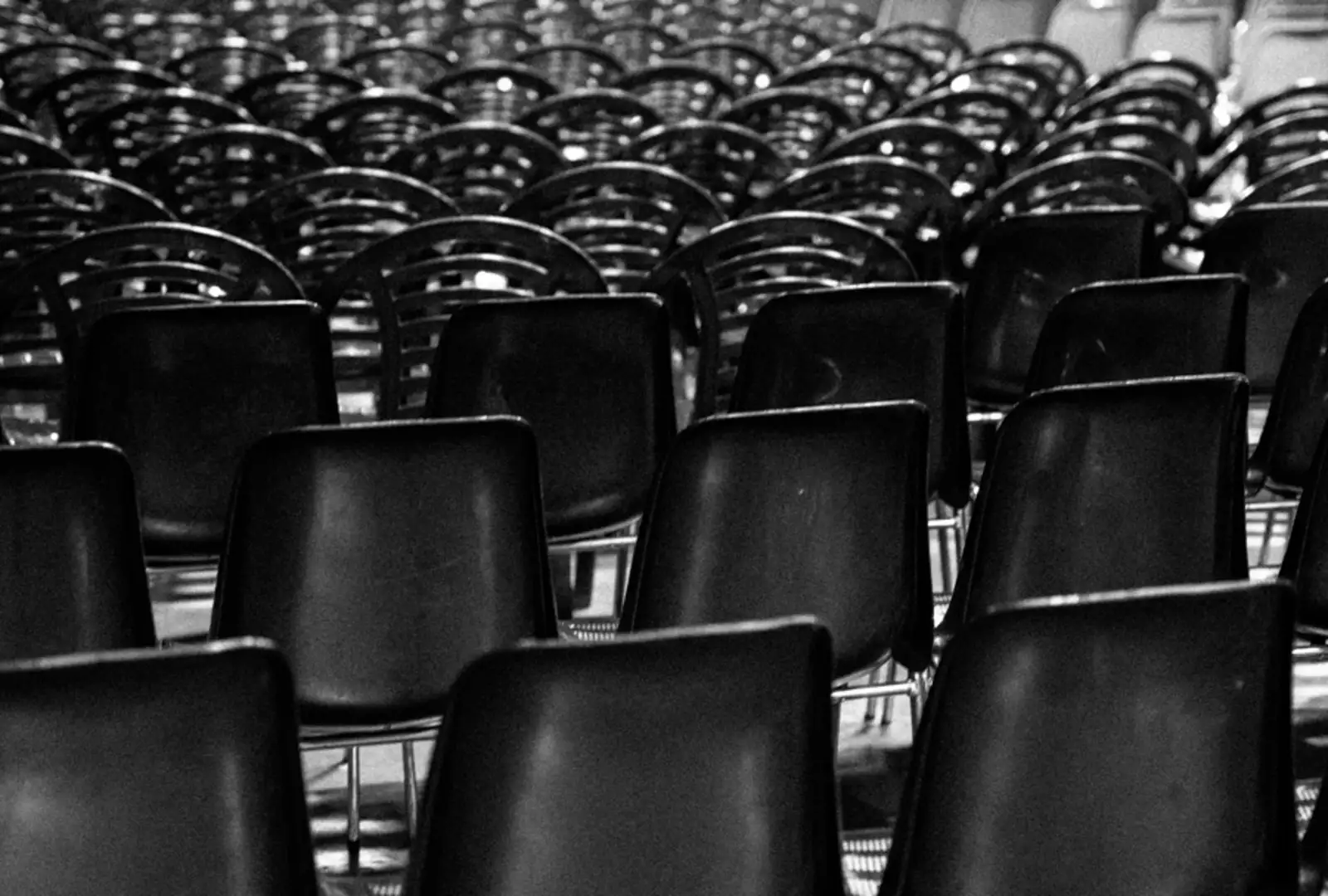 Photo en noir et blanc de beaucoup de chaises alignées 