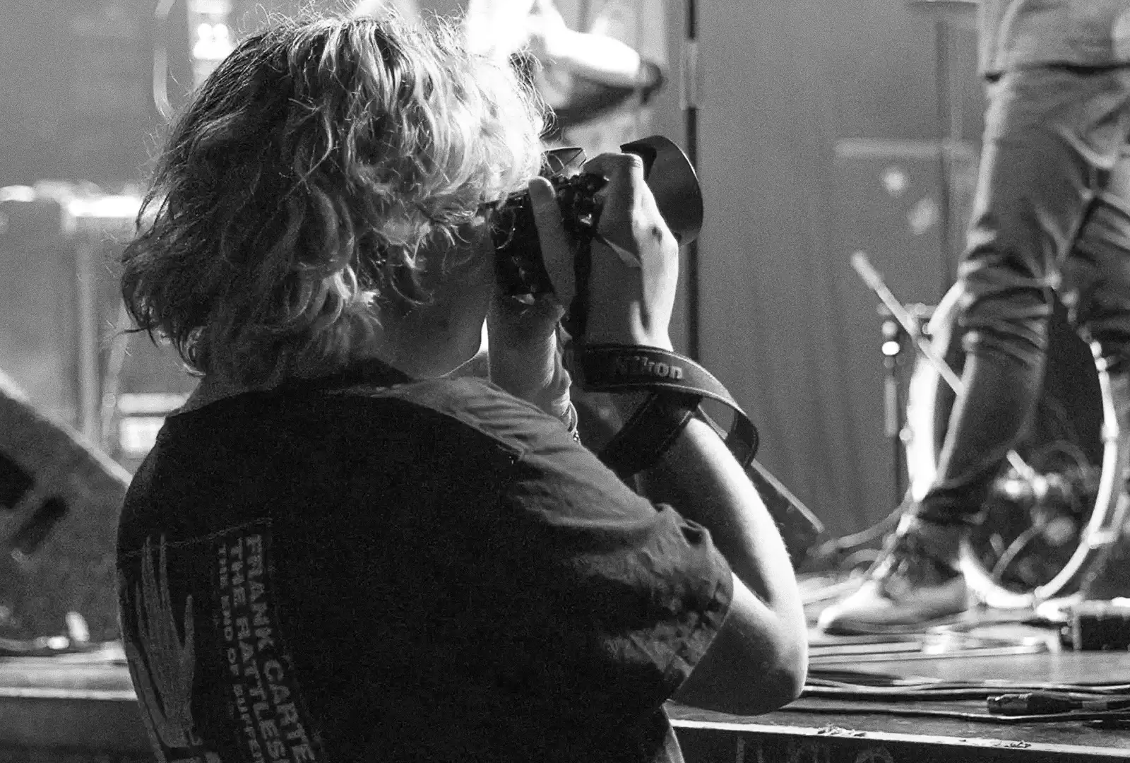 Photo en noir et blanc d'une photographe lors d'un concert