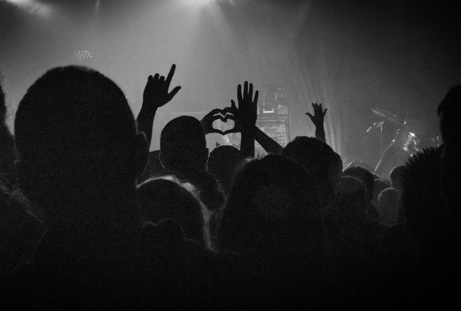 Photo noir et blanc de la foule, des mains en formes de coeur